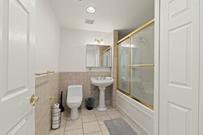 Une salle de bain avec des toilettes, un lavabo et une douche.
