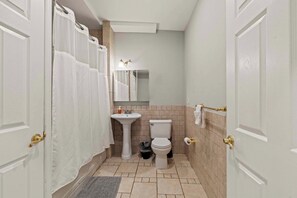 A bathroom with a toilet, sink, and shower curtain.