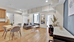 Una sala de estar moderna con sofá, mesa de centro, mesa de comedor y sillas.