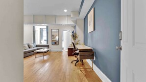 Una sala de estar moderna con un sofá, una mesa de centro y un escritorio con una silla.