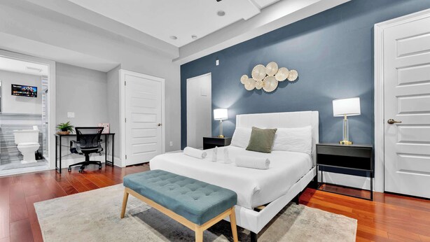 Une chambre moderne avec un grand lit, deux tables de chevet, un bureau et une chaise.