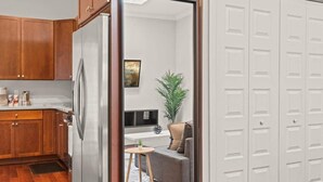 A compact kitchen with wooden cabinets and a stainless steel refrigerator. - Luxury 1BD | 2 Beds | Queens Village (Philadelphia)