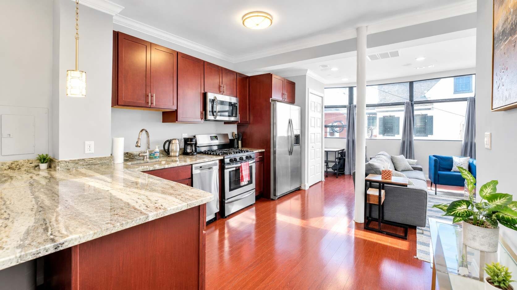 A modern kitchen with granite countertops, stainless steel appliances, and wooden cabinets.