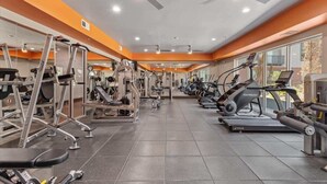 A gym with various exercise machines, including treadmills and weight stations, arranged in rows. - Upscale 2BD Deep Ellum | Parking | Pool | Gym Pass (Dallas)