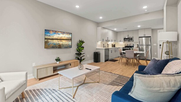 A modern living room with a sofa, a coffee table, and a painting on the wall. - Luxury 1BD | 1 Bed | Northern Liberties (Philadelphia)