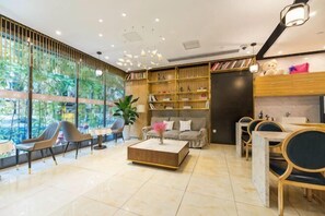 Una sala de estar moderna con sofá, sillones, una mesa de centro y una estantería.