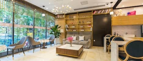 Una sala de estar moderna con un sofá, sillas, una mesita de centro y una estantería.