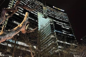 A high-rise building with illuminated windows and a visible sign at the top. - Longchen Holiday Inn (Shanghai Ruijin Hospital Yongjia Road Branch) (Shanghai)