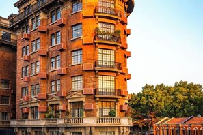 A multi-story building with a curved facade, large windows, and a balcony on the upper floors. - Longchen Holiday Inn (Shanghai Ruijin Hospital Yongjia Road Branch) (Shanghai)