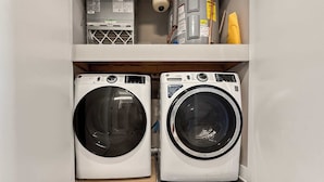A laundry room with two front-loading washing machines and a water heater above them. - Luxury Studio | 1 Bed | Northern Liberties (Philadelphia)