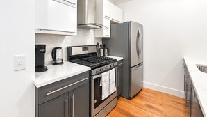 A modern kitchen with stainless steel appliances, a gas stove, and a built-in oven.