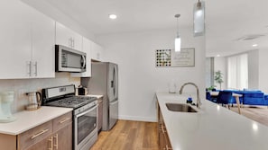 Una cocina moderna con horno empotrado, microondas y refrigerador.