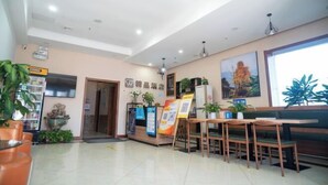 A hotel lobby with a reception desk, seating area, and a large window. - Qingxu Jinrui 99 Boutique Hotel (Qingxu)