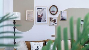 A room with a sofa, a wall-mounted air conditioner, and framed pictures. - Qingxu Jinrui 99 Boutique Hotel (Qingxu)