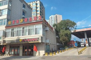 Un edificio con escaparates y una gasolinera al fondo.