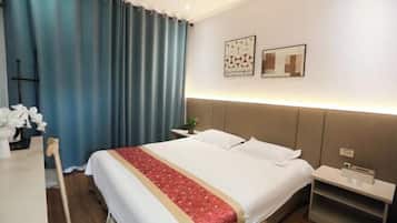 A hotel room with a bed, a nightstand, a desk, and a chair.