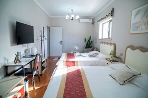 A hotel room with two beds, a desk, a TV, and a window with a plant. - Qingxu Jinrui 99 Boutique Hotel (Qingxu)