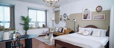 A bedroom with a bed, bedside table, and a desk with a chair.