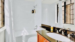 A modern bathroom with a bathtub, a sink, and a mirror.