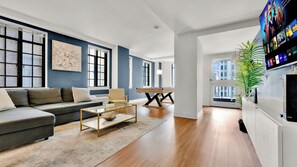 A modern living room with a sofa, coffee table, and a pool table.