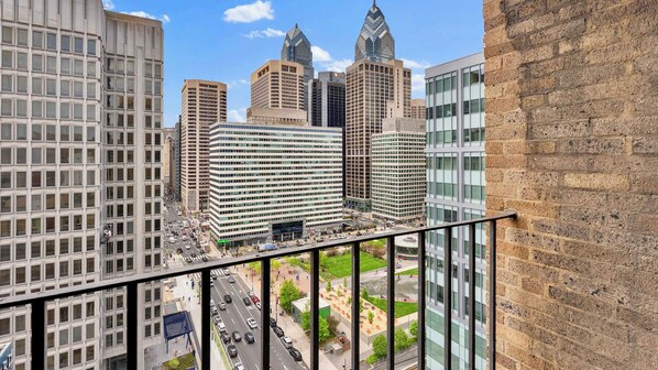 A high-rise building with a view of a busy street and other buildings.