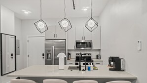 A modern kitchen with a central island, stainless steel appliances, and pendant lighting. - Modern 3-Bedroom Oasis in Center City (Philadelphia)