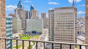 A cityscape with modern high-rise buildings, a central plaza, and a historic building with a statue. - Luxury 2BD | Center City | 4 Beds | Near LOVE Park (Philadelphia)