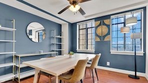 A dining area with a wooden table, chairs, and a ceiling fan. - Luxury 2BD | Center City | 4 Beds | Near LOVE Park (Philadelphia)