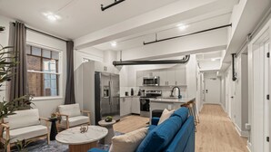 A modern apartment with a living room, kitchen, and dining area.