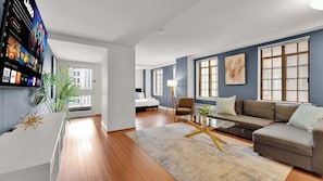 Un salon moderne avec un canapé, une table basse et un téléviseur fixé au mur.