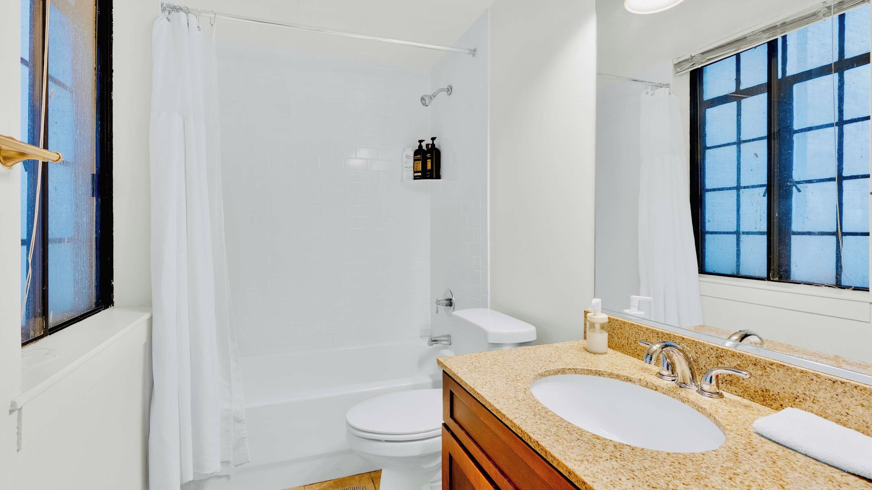 Une salle de bain avec une douche, des toilettes et un lavabo avec un miroir.