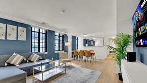 Uma sala de estar moderna com sofá, mesa de centro e área de refeições.