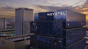 Un moderno edificio de hotel con el nombre 'NOVOTEL' bien visible.