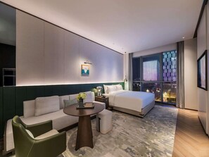 A modern hotel room with a bed, sofa, and a small table. - Novotel Xian Xixian (Xianyang)