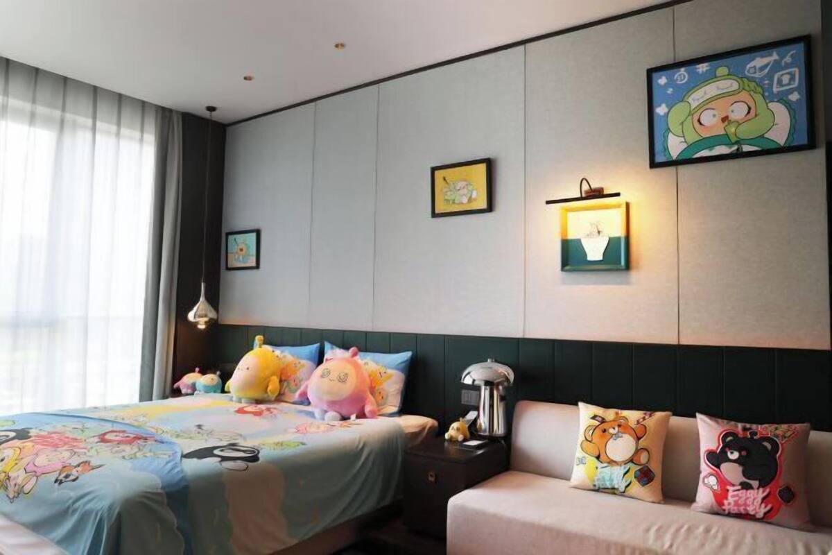 Ein Hotelzimmer mit Bett, Nachttisch, Lampe und Wandbildern.