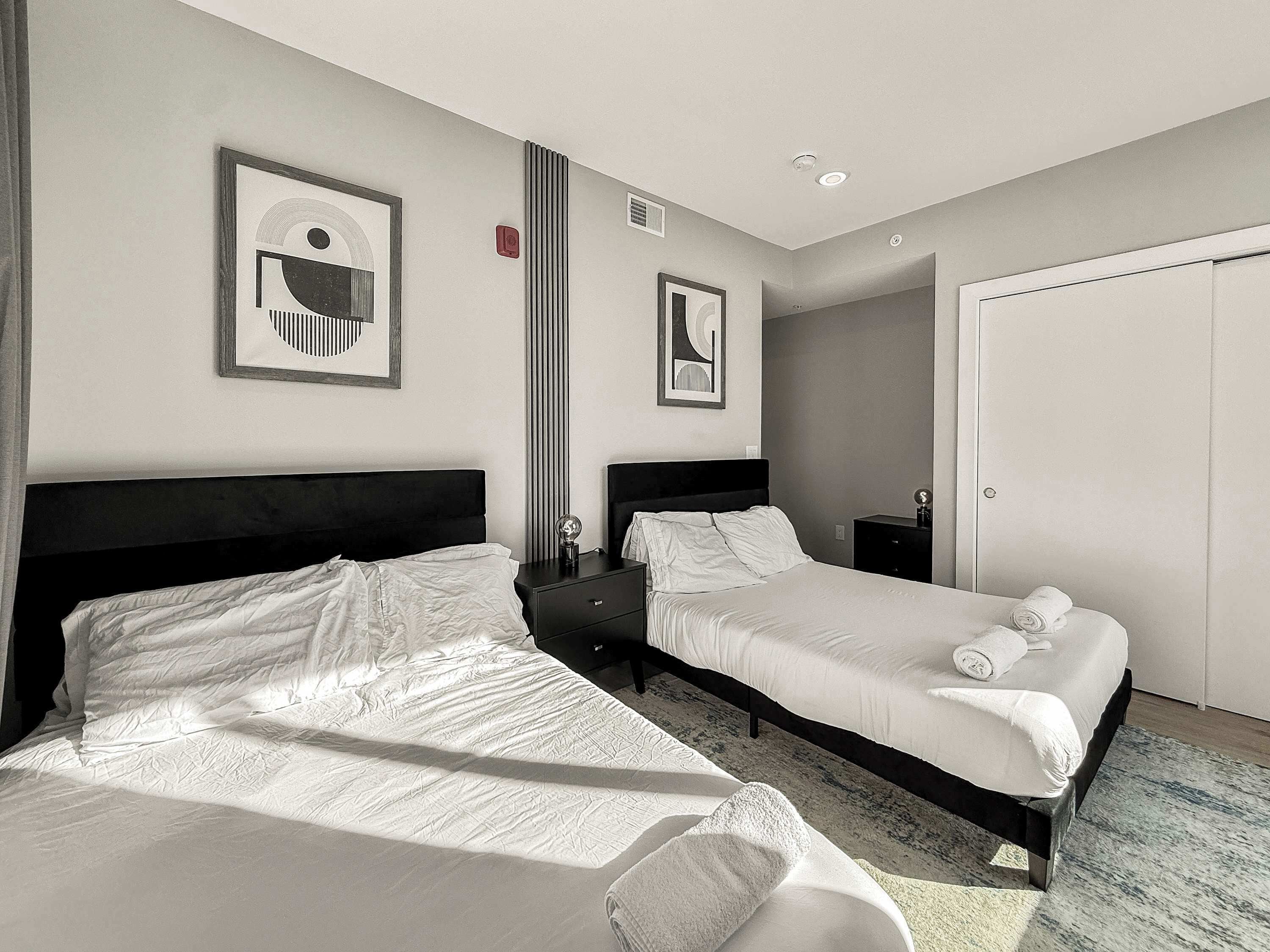Ein Hotelzimmer mit zwei Betten, einem großen Spiegel und einem Kleiderschrank.