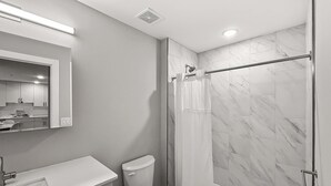 A modern bathroom with a toilet, sink, and shower area. - Luxury 1BD | 2 Beds | Northern Liberties (Philadelphia)