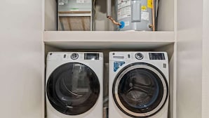 Two front-loading washing machines in a utility room with a white wall and a wooden floor. - Luxury 1BD | 2 Beds | Northern Liberties (Philadelphia)