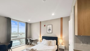 Ein Hotelzimmer mit Bett, Nachttischen, Schreibtisch und Stuhl.