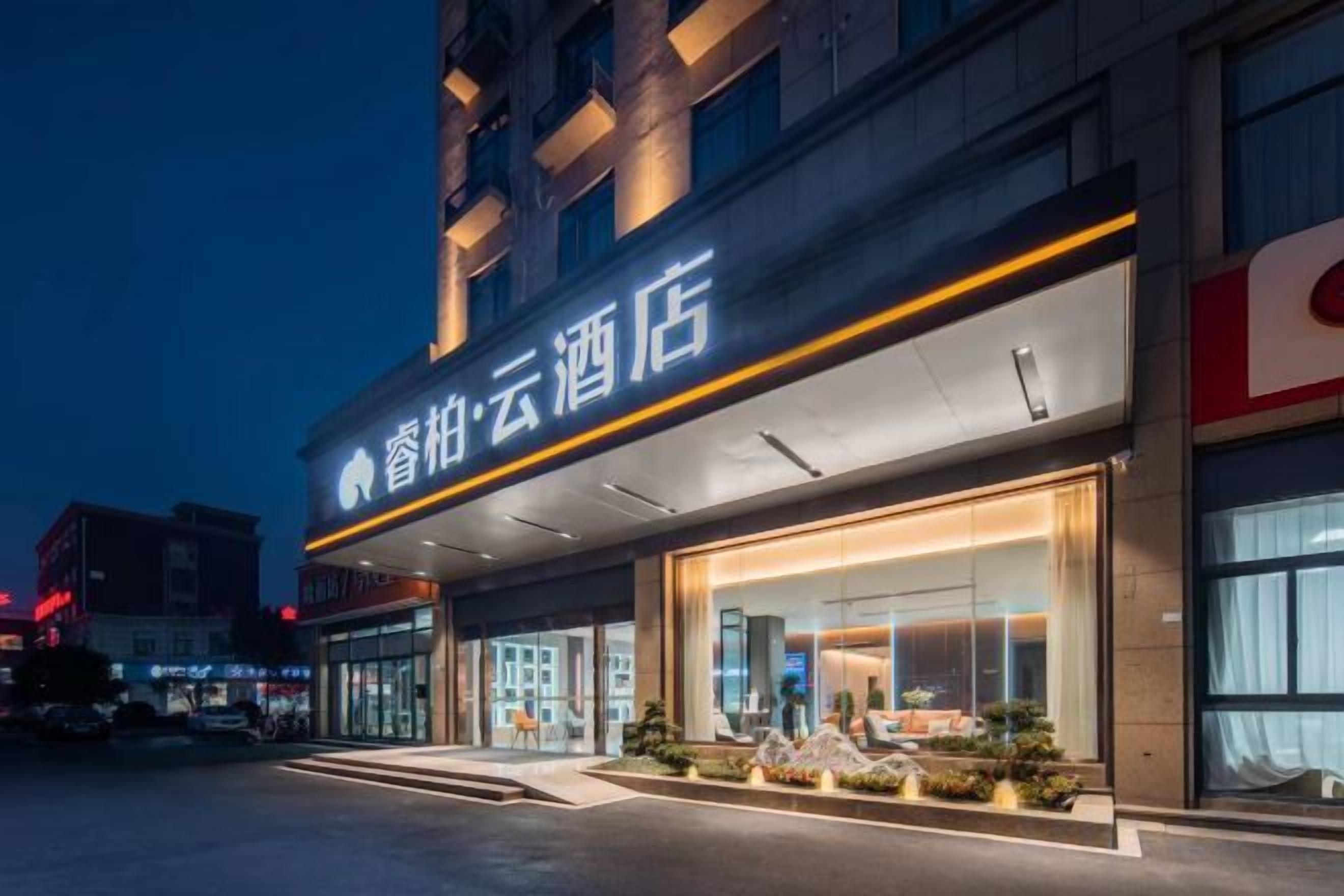 A hotel with a modern facade, large glass windows, and a prominent entrance.
