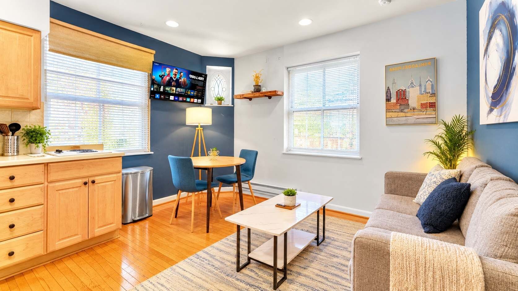 A modern living room with a sofa, a coffee table, and a TV mounted on the wall.