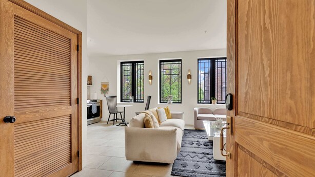 A spacious living area with a sofa, a dining table, and a kitchen in the background. - Luxury 1BD | 1 Bed | South St (Philadelphia)