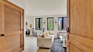 A spacious living area with a sofa, a dining table, and a kitchen in the background.