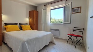 A bedroom with a bed, a wardrobe, a window, and a radiator. - Villa near Solenzara (Ventiseri)