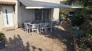 An outdoor patio with a table and chairs, a grill, and potted plants. - Villa near Solenzara (Ventiseri)
