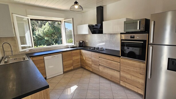 A modern kitchen with a dishwasher, microwave, oven, and refrigerator. - Villa near Solenzara (Ventiseri)