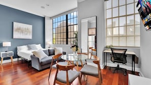 A modern living room with a sofa, chairs, a glass table, a desk, and a large window. - Luxury Studio | Northern Libs | 1 Bed | Onsite gym (Philadelphia)