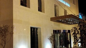 L’extérieur de l’hôtel Sunlun International se distingue par une enseigne bien visible, de grandes fenêtres et une entrée bien éclairée.