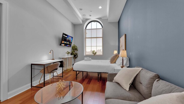 A modern room with a bed, a sofa, a desk, and a TV. - Luxury Studio | Northern Libs | 1 Bed | Onsite gym (Philadelphia)