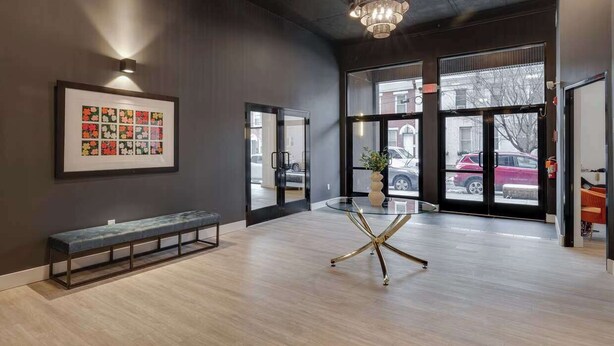 A modern interior with a bench, a glass table, and a framed artwork on the wall. - Cozy 2BD Apt | Fishtown | Gym (Philadelphia)